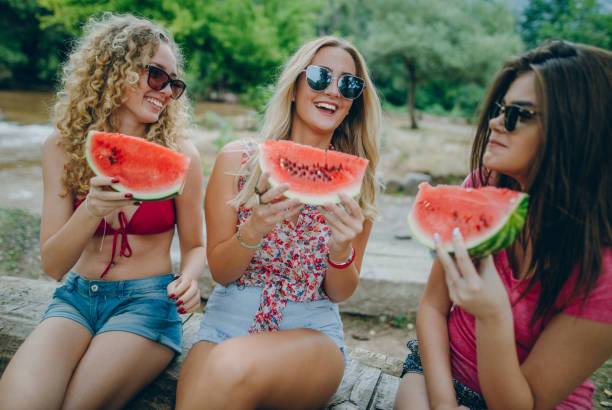 istock Girlfriends laughing and eating watermelon 839410218