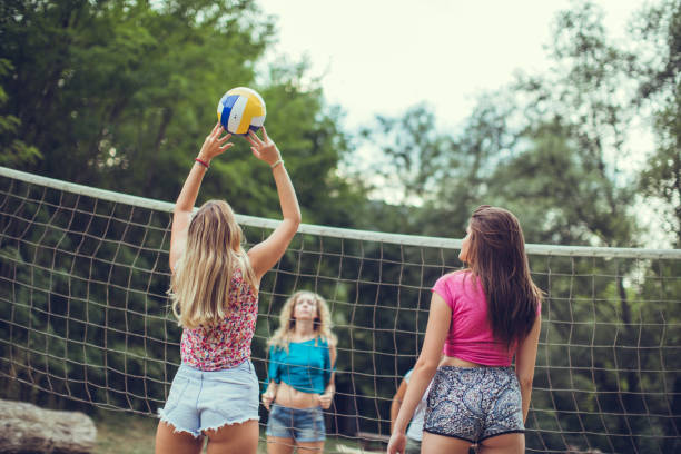 Friends playing volleyball at public park