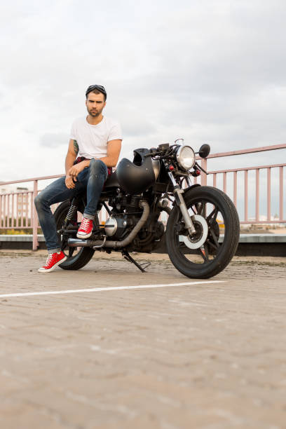 istock Brutal man sit on cafe racer custom motorbike. 839418384
