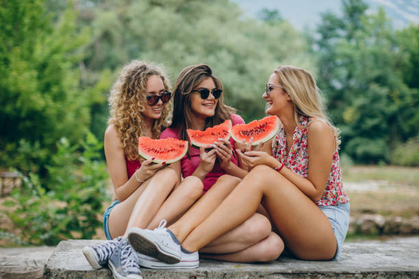 istock Girlfriends laughing and eating watermelon 839494694