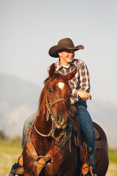istock Young Cowboy Sitting on Horse Laughing 839519350