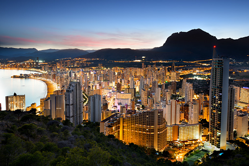 Benidorm skyline with skyscraper lights and mountains at sunset