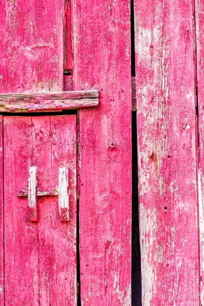 Abstract closeup pattern of red painted old vintage shed door with handle in countryside