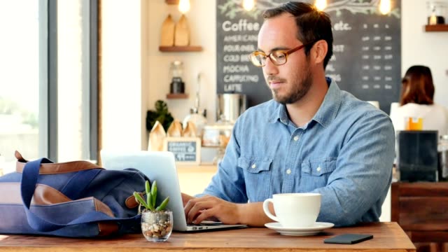 Young businessman telecommutes from local cafe