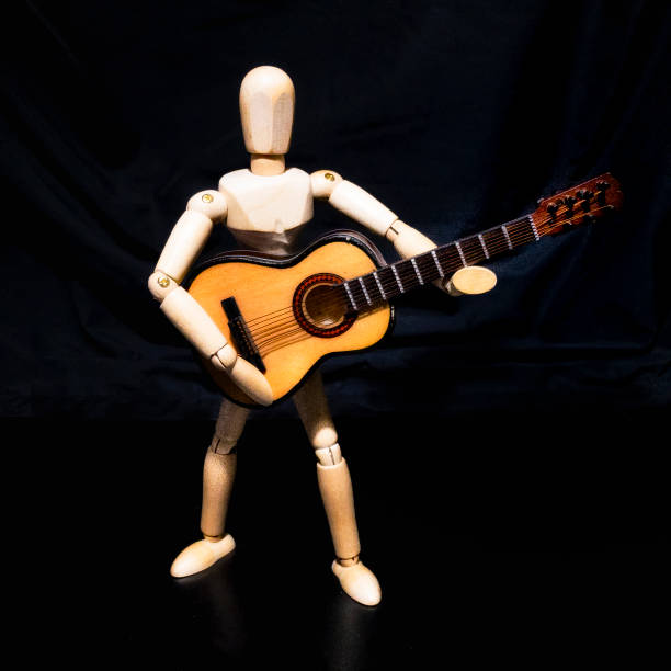 istock Wooden man figure playing guitar 839654408