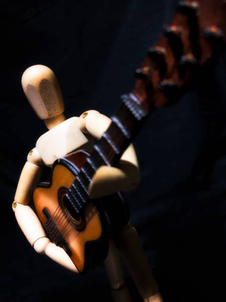 istock Wooden man figure playing guitar 839655076