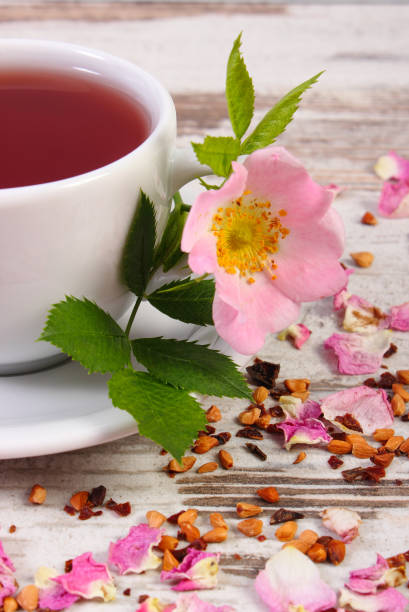 istock Cup of hot tea with wild rose flower on old rustic plank 839791274