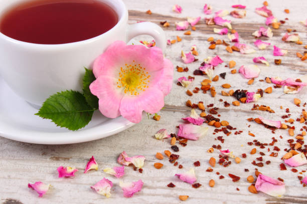 istock Cup of hot tea with wild rose flower on old rustic plank 839791508