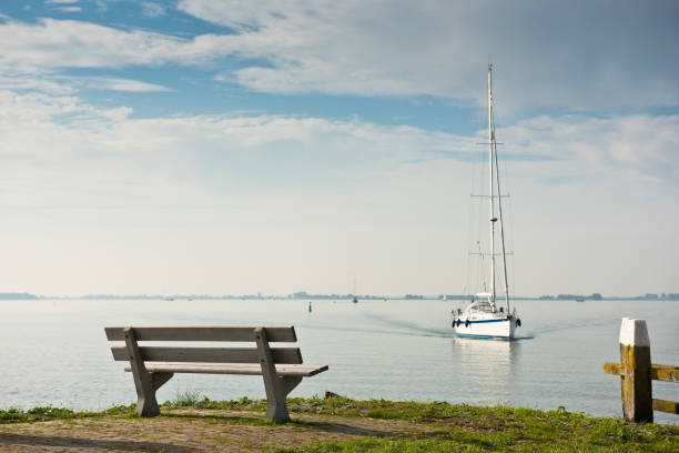istock Scenic sea view with bench and sailboat 839798006