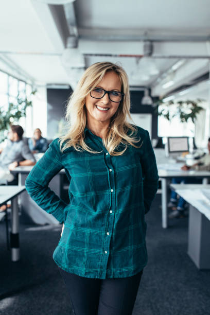 istock Smiling mature female standing in office 839819948