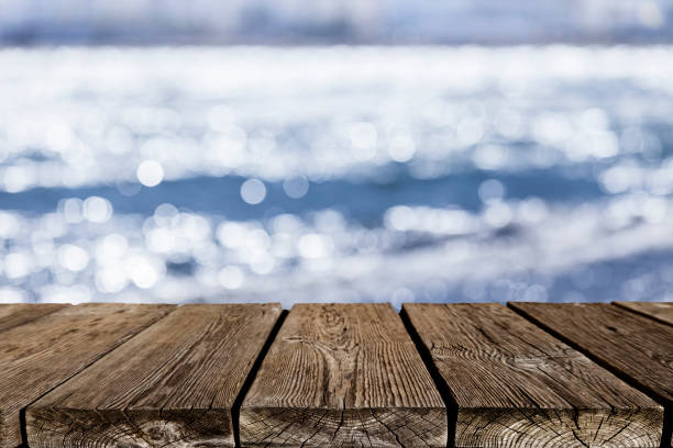 istock Empty rustic wooden table with defocused sea water at background 839822460