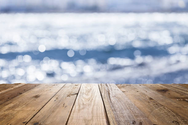istock Empty rustic wooden table with defocused sea water at background 839822466