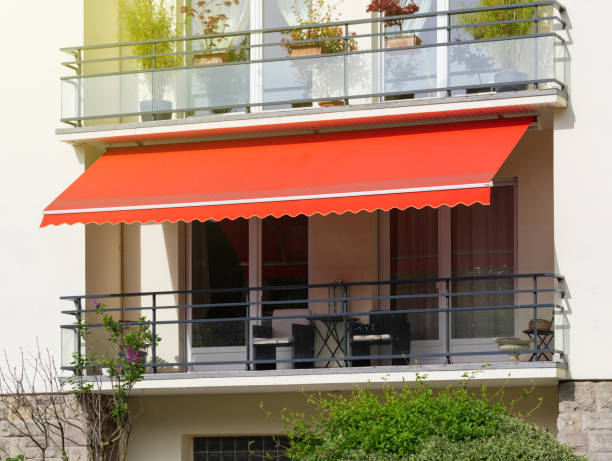 Sun protection awning at French balcony French balcony with awning opened covered by sun-shield on a warm summer day awning stock pictures, royalty-free photos & images