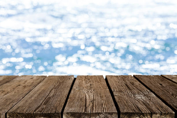 istock Empty rustic wooden table with defocused sea water at background 839840934