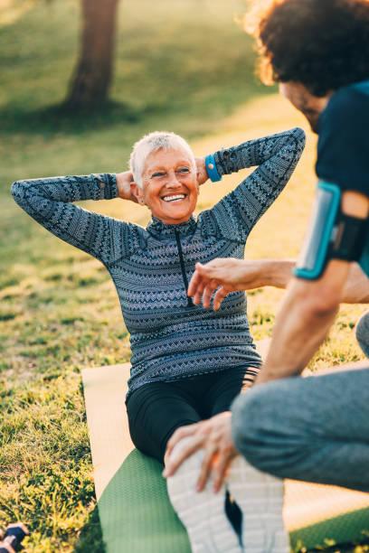 istock Senior woman doing crunches with a personal trainer 839846422