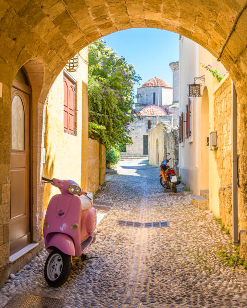 Postcard view of narrow street with motorbike. Rhodes, Greece stock photo