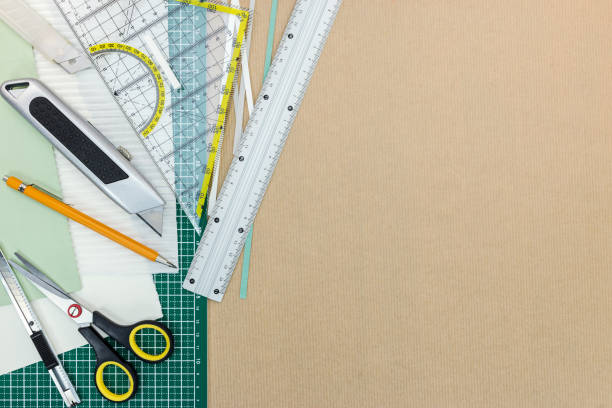 istock brown desk with green cutting mat, cutter, ruler, scissors an pencil 839859656