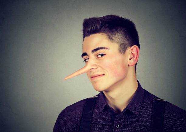 Liar funny looking young man with long nose Liar funny looking young man with long nose on gray background falsehood stock pictures, royalty-free photos & images