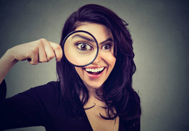 istock Curious surprised woman looking through a magnifying glass 839871394