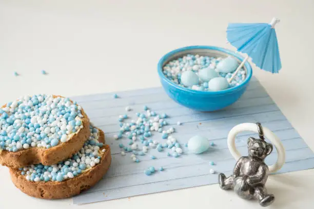 traditional dutch biscuits with blue muisjes and silver toy rattle