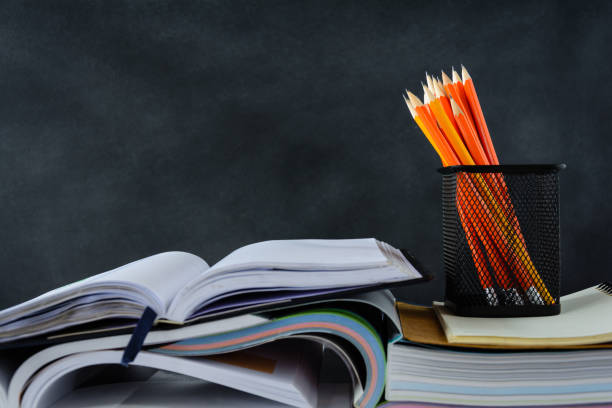 istock book and pencil on white table black board background 839879208
