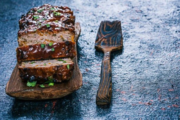 Woman hands cutting piece of meatloaf, she prepare for tasting of food at kitchen. Chef cutting meatloaf with knife on board on restaurant kitchen table. Housewife sliced meatloaf on cutting board.