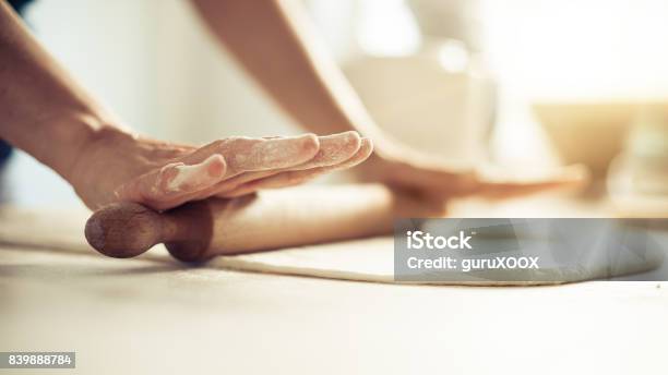 Woman Rolling Dough On Wooden Table With Wooden Rolling Pin Stock Photo - Download Image Now