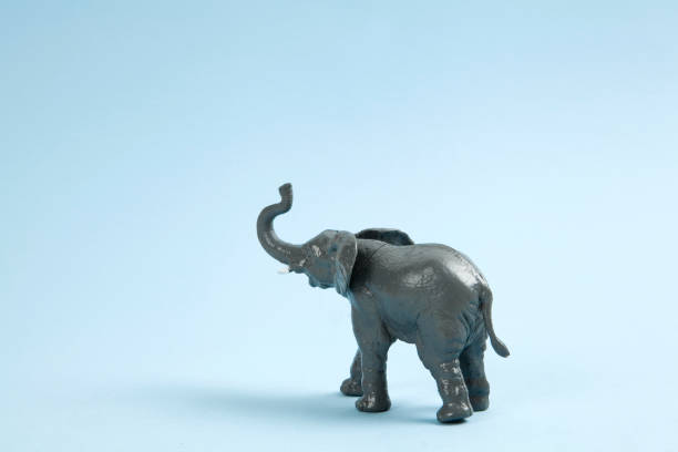 pop elephant figurine a plastic elephant on a vibrant blue background. Minimal color still life photography elephant figurine stock pictures, royalty-free photos & images