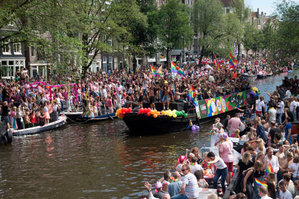 glückliche menschen während der canal pride in amsterdam - city amsterdam urban scene gay parade stock-fotos und bilder