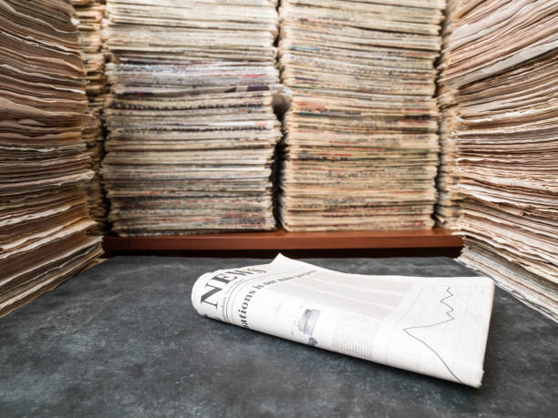 View of large amount of documents, newspapers, and books in classic library. A newspaper is seen on desk. The newspaper is a self designed fake one. No people are seen in frame. Shot with a medium format camera.