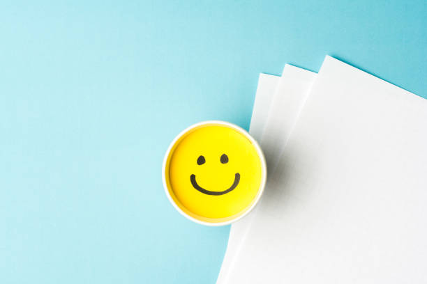 istock Happy emoticon/face and copy space on blue background and white papers 839908074
