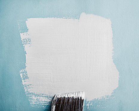 White paint swatch painted on blue wall