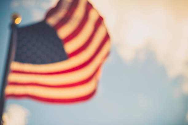 istock Defocused American flag against blue summer sky 839938630