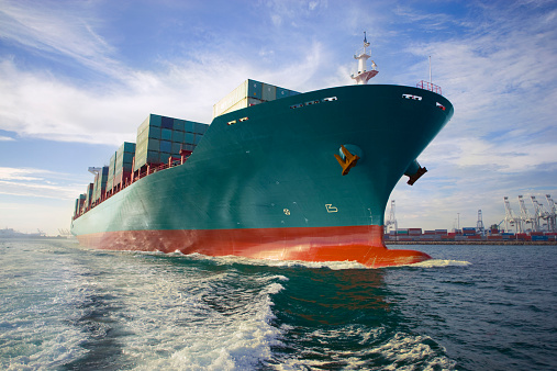 istock Bow view of loaded cargo ship sailing out of port. 83994439
