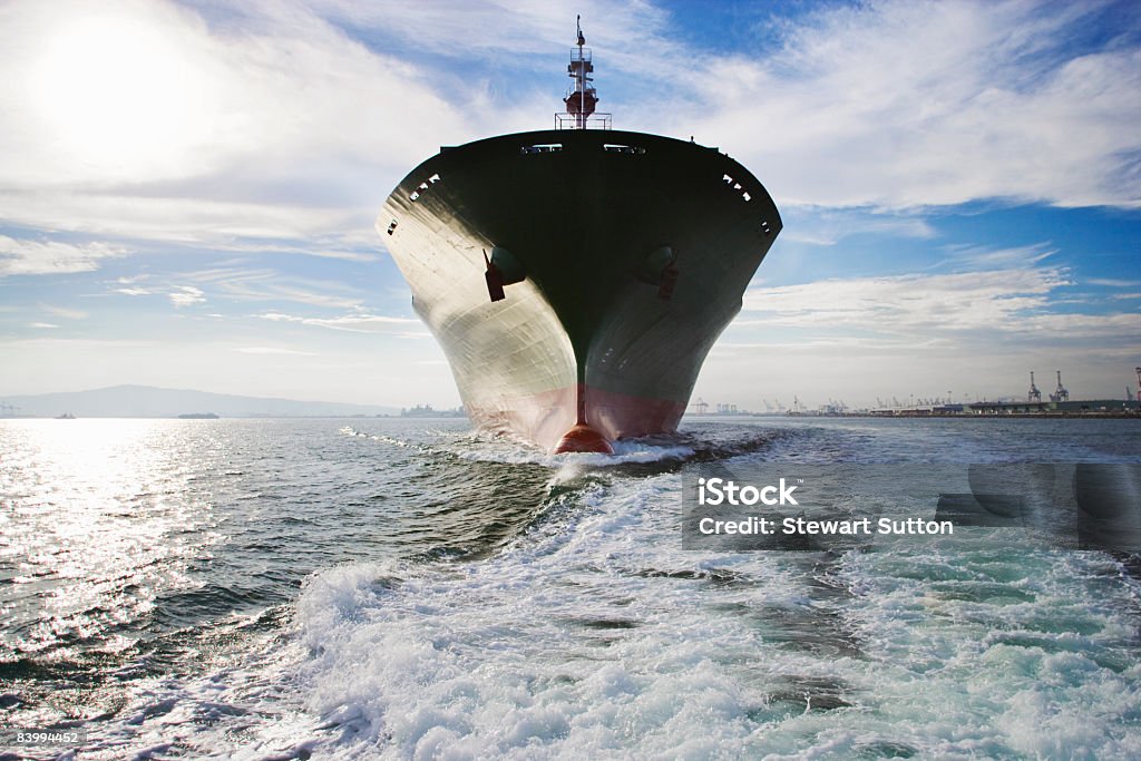 Bow view of cargo ship sailing out of port.  Ship's Bow Stock Photo