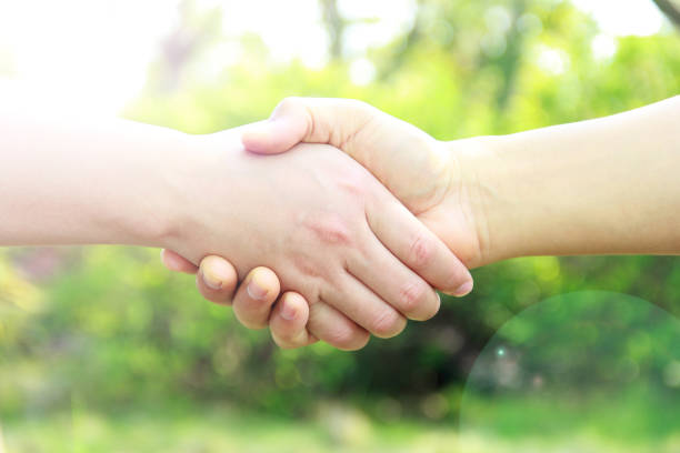 istock Man and woman hand shaking on nature background 839947898