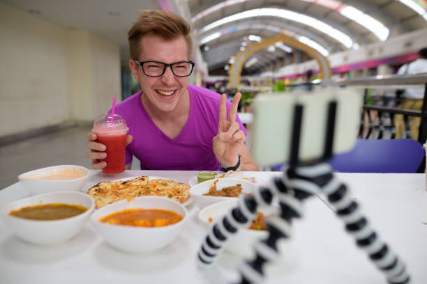 ritratto di giovane bell'uomo che gusta la cucina indiana al ristorante - scandinavian men glasses shirt foto e immagini stock