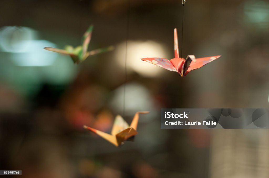 Paper Cranes Colored paper folded into three oragami paper cranes hung from string as if flying. Origami Stock Photo