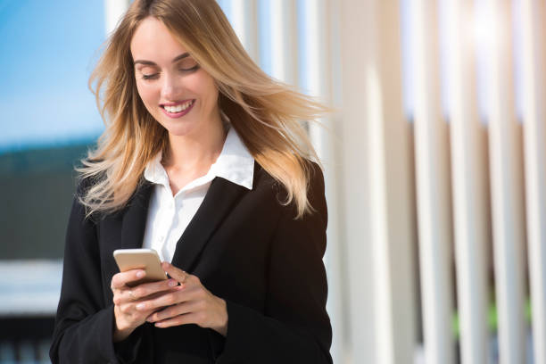 istock beautiful young business woman executive is using an application in her smart phone to check email or send a text message 839952698