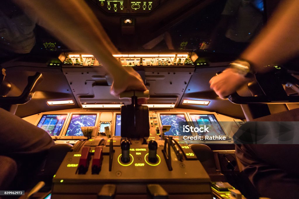 Boeing 777 Night Flight over Europe Two pilots at work after departure of Amsterdam International Airport Netherlands. The view from the flight deck with high workload Cockpit Stock Photo