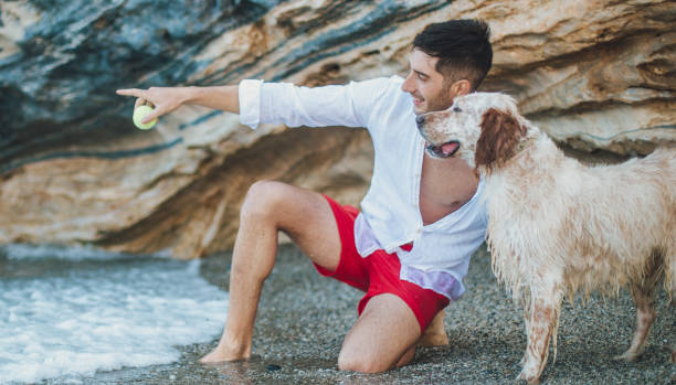 Man playing with his dog on the beach