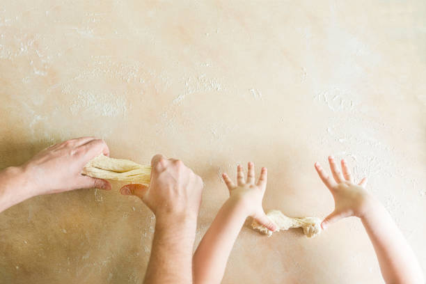 istock Children's and dad's hands makes raw dough 839982512