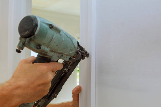 istock Carpenter brad using nail gun to moldings on doors, 839986006