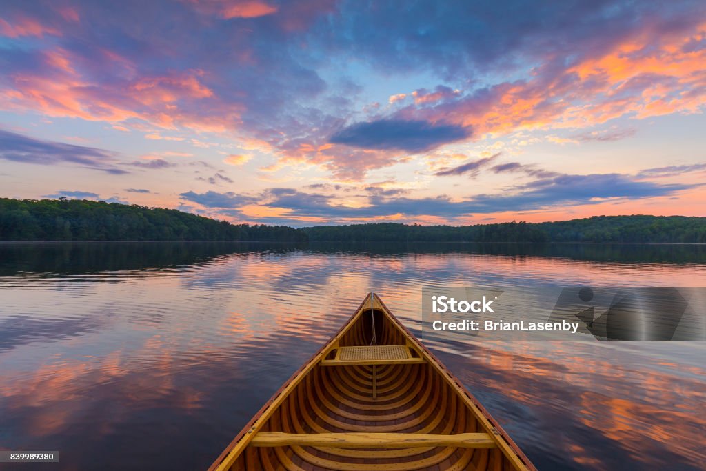 Bow of a cedar canoe on a lake at sunset - Ontario, Canada Bow of a cedar canoe on a lake at sunset - Haliburton, Ontario, Canada Lake Stock Photo