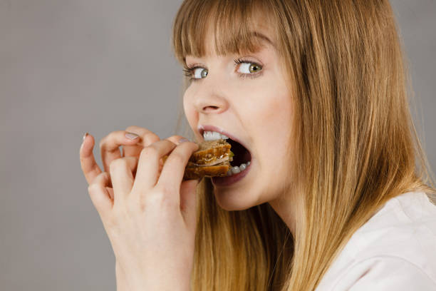 istock Woman eating sandwich, taking bite 839990300
