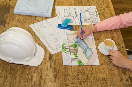 Woman working, projecting on wood table, architect, engineer.