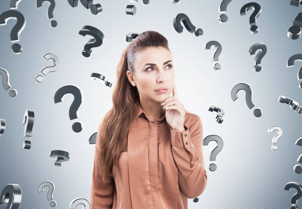 istock Pensive woman in brown, question marks 839999878