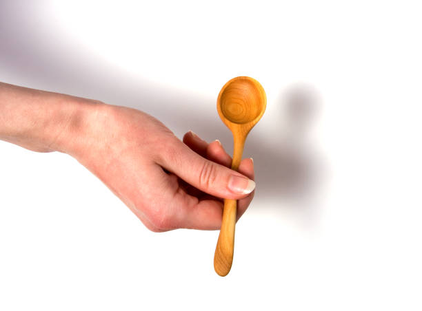 istock Hand holding wooden spoon isolated on white background 840028062