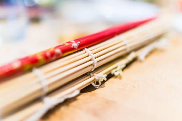 istock Macro closeup of red chopsticks and sushi mat 840043884