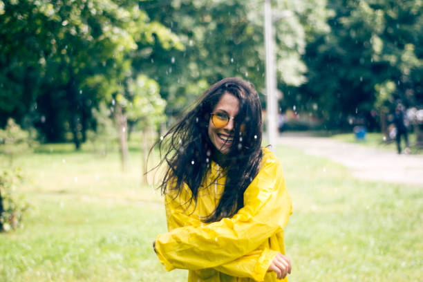 Young woman in a rainy day with a yellow raincoat